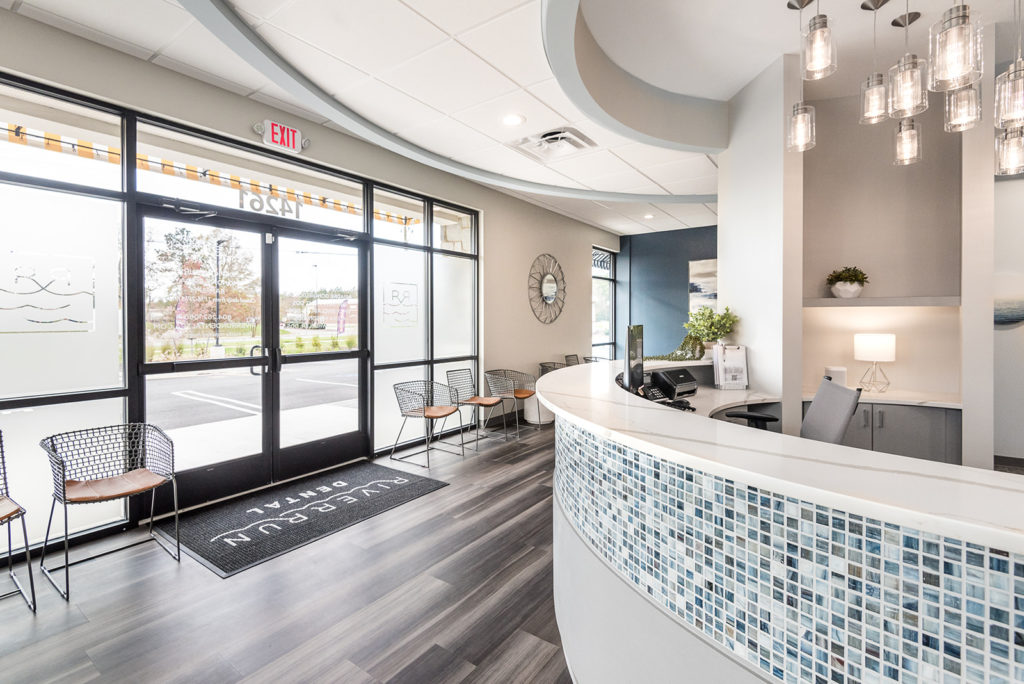 Dental office entrance and reception area with large windows and modern interior design