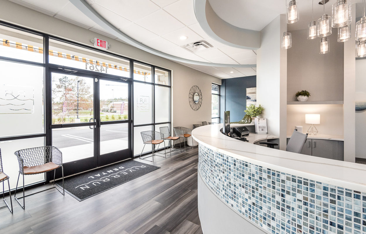 Dental office entrance and reception area with large windows and modern interior design
